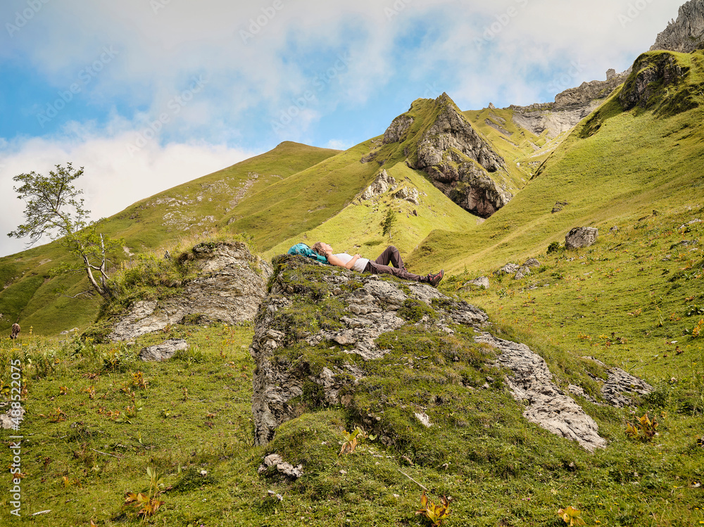 Woman resting on grassy rock Woman resting on grassy rock