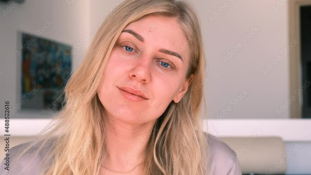 Young alluring blonde woman with blue eyes looks peacefully into the camera, 4k, slow motion Young alluring blonde woman with blue eyes looks peacefully into the camera, 4k, slow motion