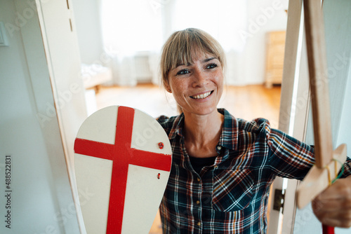 Smiling woman with sword and shield at home photo