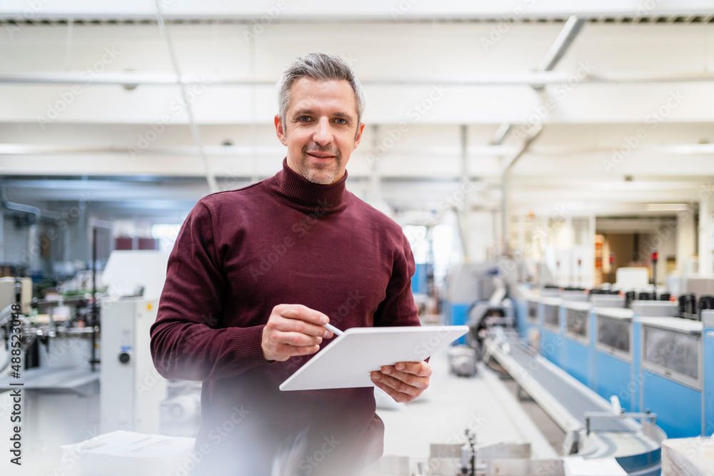 Smiling businessman with tablet PC in industry Smiling businessman with tablet PC in industry