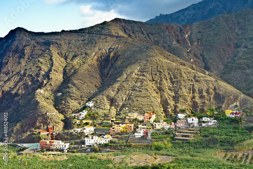 Hermigua village, La Gomera, Canary Islands: Colorful houses on a mountain slope and banana fileds in the valley, in winter. photo