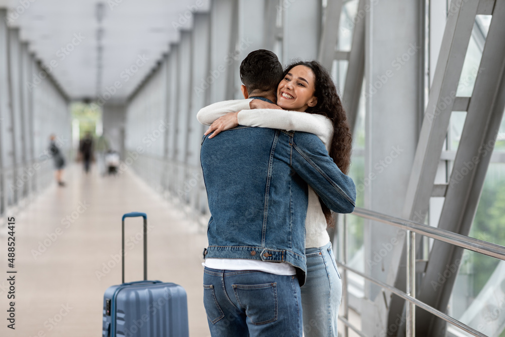 Happy Meeting. Overjoyed Young Woman Hugging Her Boyfriend At Airport After Arrival