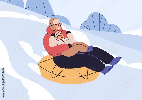 Mother and kid on snow tubing sliding down hill slope on winter holidays. Par...