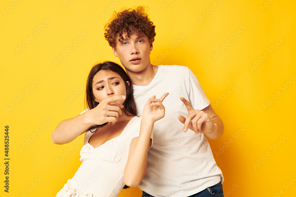 cute young couple standing side by side in white t-shirts posing Lifestyle unaltered cute young couple standing side by side in white t-shirts posing Lifestyle unaltered