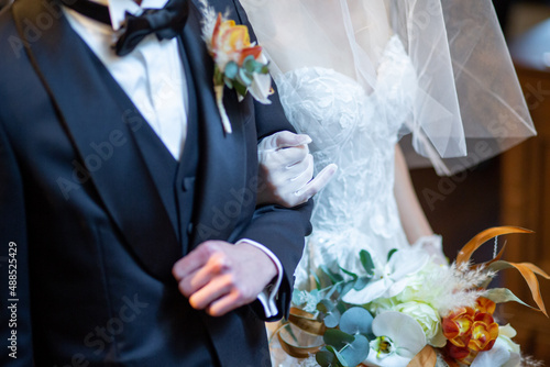 腕を組んで新婦の前に立つ新郎新婦