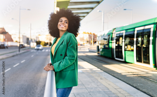Smiling commuter standing at tram station photo