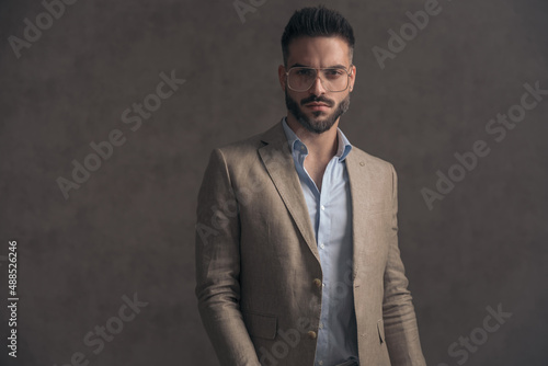 sexy unshaved man with glasses in beige suit posing in a cool manner © Viorel Sima