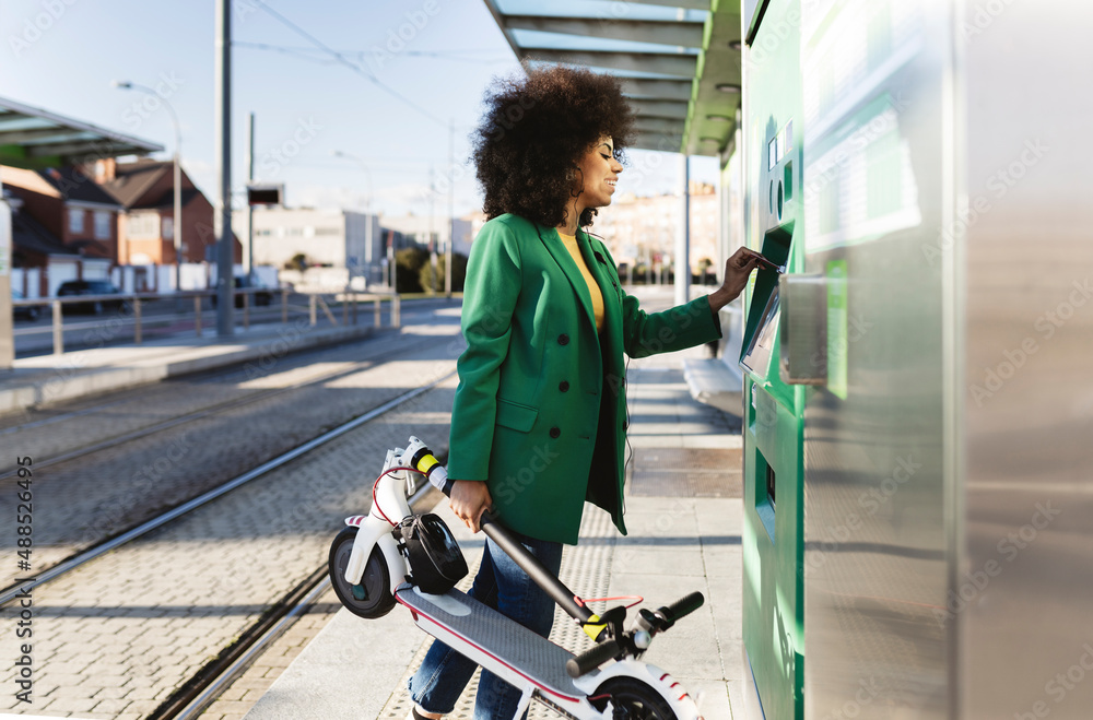 © Westend61 - Commuter buying ticket from machine at tram station