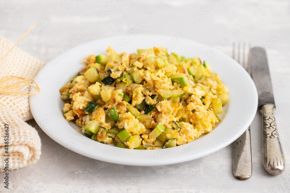 scrambled egg with zucchini on white small plate scrambled egg with zucchini on white small plate