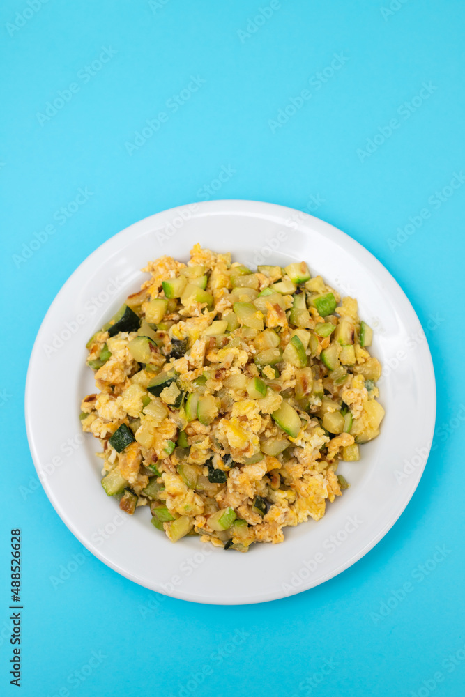 scrambled egg with zucchini on white small plate scrambled egg with zucchini on white small plate