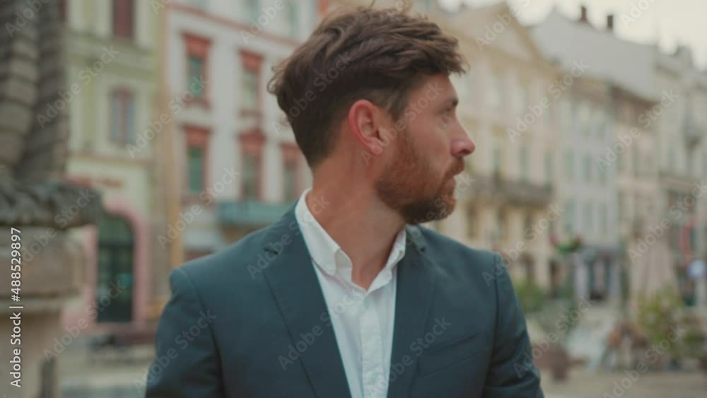 Unemployed depressed young business man wearing suit sitting outdoors empty street downtown frustrating feel very unhappy about job loss. Crisis 2020. Quarantine.