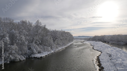 Mountain river in winter. On the shore of which are beautiful trees