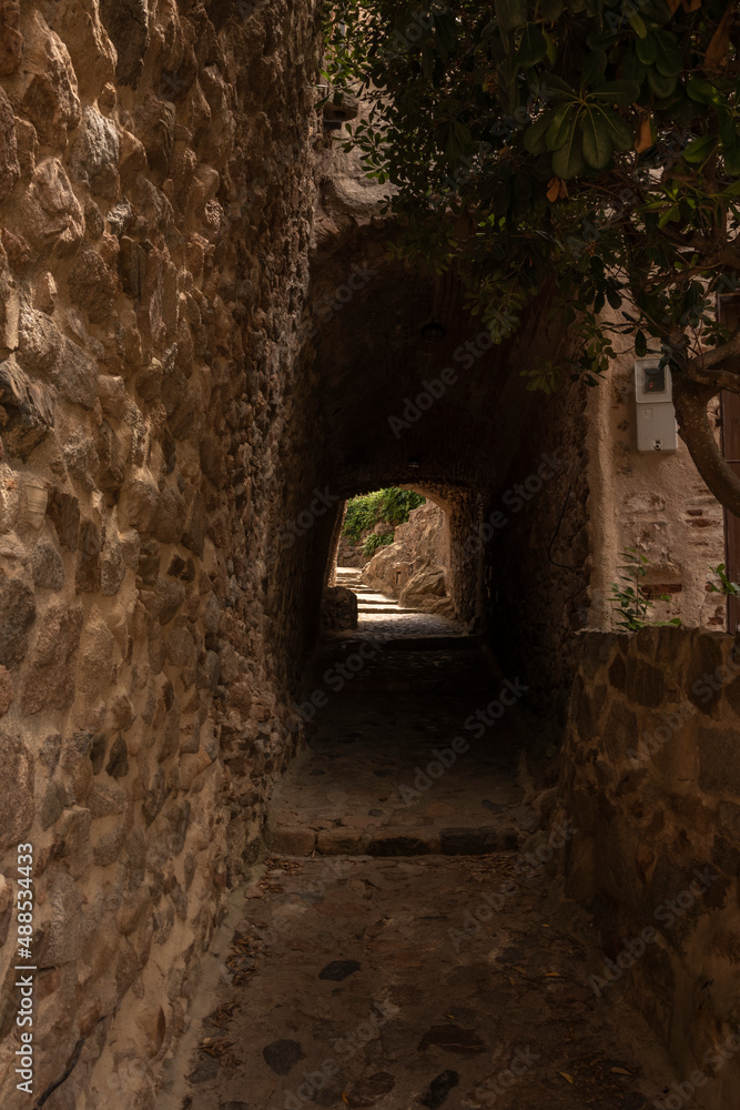 alley in tossa de mar through a narrow tunnel alley in tossa de mar through a narrow tunnel