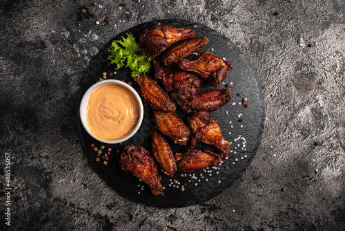 Fotografi Baked chicken wings with sweet chili sauce on slate board