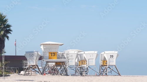 Lifeguard stand and palm tree, life guard tower for surfing on California beach. Summer pacific ocean in USA aesthetic. Iconic rescue baywatch station, coast lifesavers wachtower hut or house by sea.