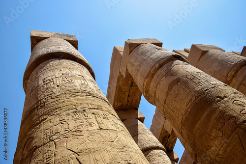 Ancient Egyptian hieroglyphs and symbols carved on columns of the complex of Karnak temple. Great Hypostyle Hall at Temples of Karnak (ancient Thebes). Luxor, Egypt