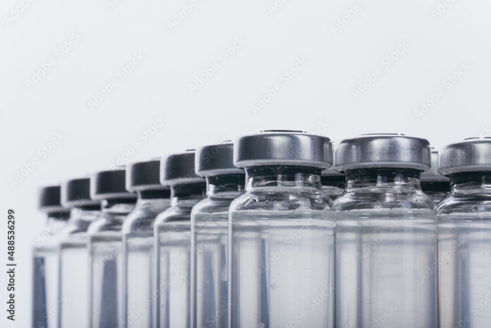 Glass medical ampoule vial for injection. Medicine is dry white drug penicillin powder or liquid with of aqueous solution in ampulla. Close up. Bottles ampule with aluminum cap on backgrounds gray. - obrazy, fototapety, plakaty 