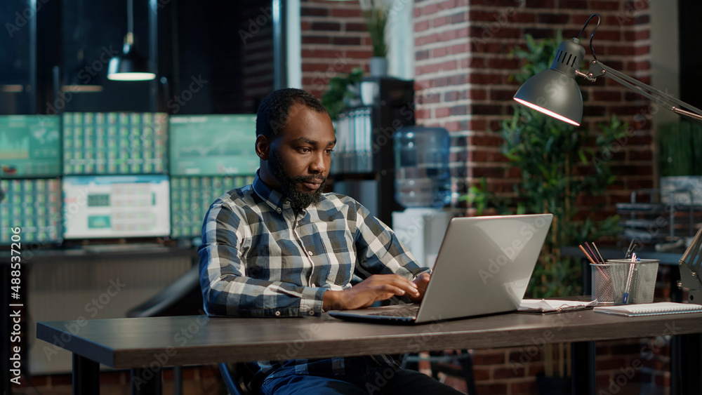 Portrait of african american man using laptop to plan global stock trade, working with forex sales and money exchange for business investment. Capital profit growth, index price. Portrait of african american man using laptop to plan global stock trade, working with forex sales and money exchange for business investment. Capital profit growth, index price.