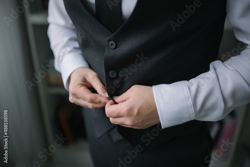 Young handsome man in classic suit. Young businessman puts on suit and prepares for a meeting.