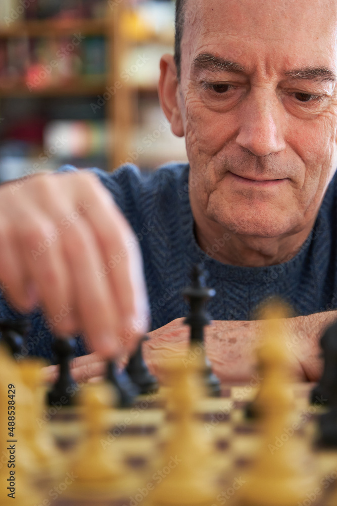 Brain training for senior citizens. Man playing chess and smiling Brain training for senior citizens. Man playing chess and smiling
