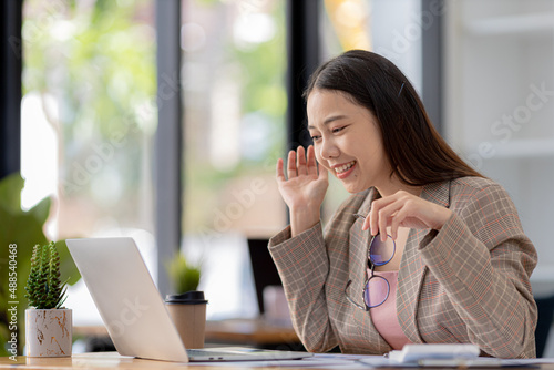 Businesswoman chatting with business partner via video call on laptop, she is meeting with partner on planning, operations and finance of a joint startup company. Business administration concept. © kamiphotos