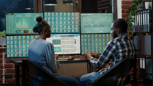 Brokers doing teamwork to create forex exchange sales growth, using multi monitors workstation. Analyzing stock trade market numbers to plan financial investment strategy. Tripod shot. © DC Studio