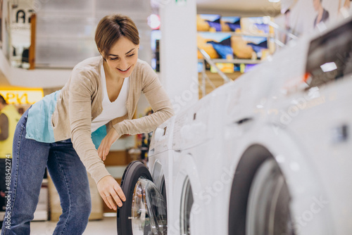 Woman choosing wasing machine at electronics store