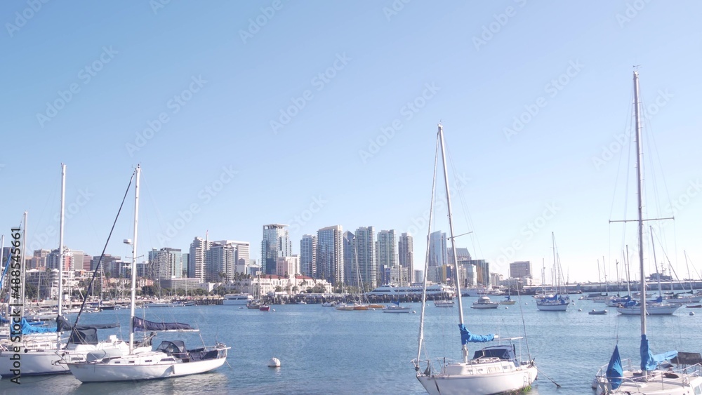 Yachts in marina and downtown city skyline, San Diego cityscape, California coast, USA. Highrise skyscrapers and boat in bay, waterfront harborside promenade. Urban architecture and sailboat in harbor