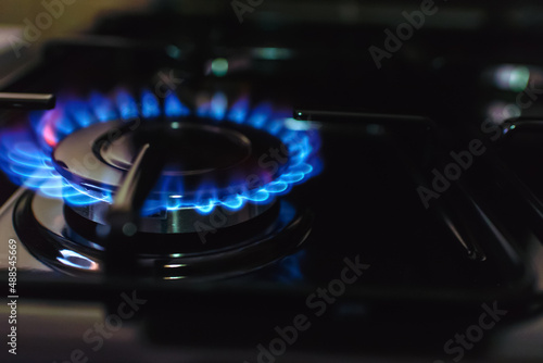 Gas burning from a kitchen gas stove at home.Gas flame with blue reflection.Close-up,selective focus.