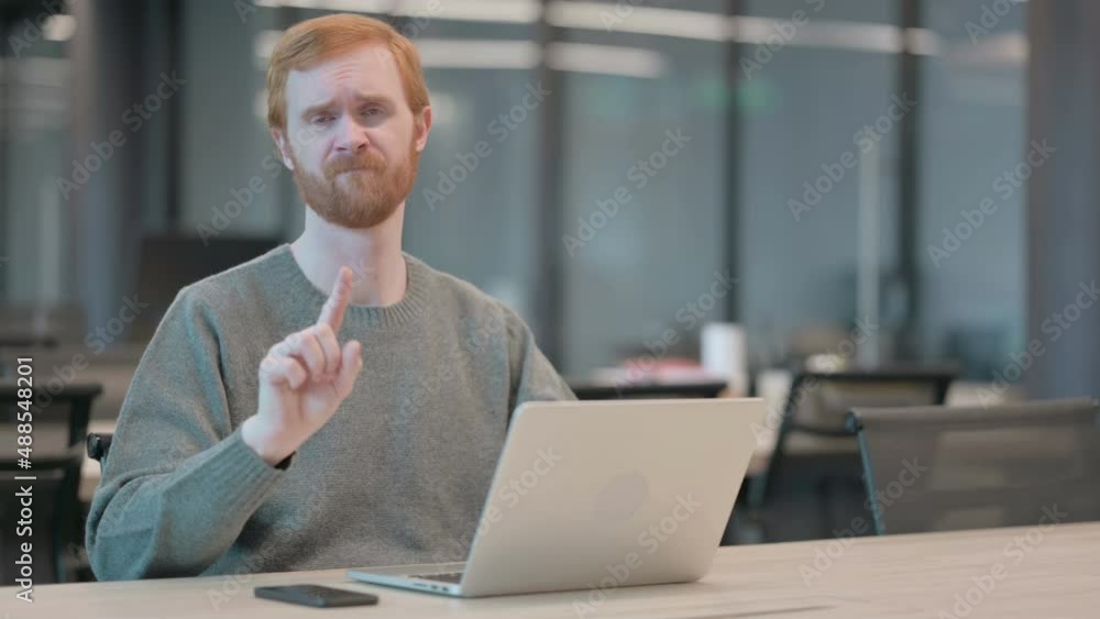 Young Man Shaking Head as No Sign while using Laptop in Office Young Man Shaking Head as No Sign while using Laptop in Office