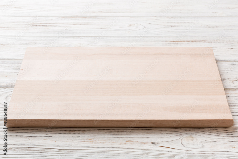 Perspective view of wooden cutting board on wooden background. Empty space for your design Perspective view of wooden cutting board on wooden background. Empty space for your design