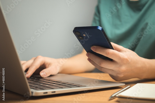 Laptop on wooden desk and young woman hand on keyboard. Freelance workplace, work from home concept background photo