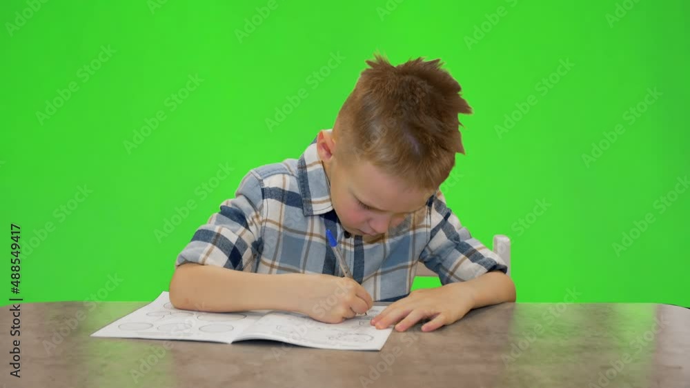 Boy 5 years old writes in a notebook Boy 5 years old writes in a notebook