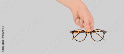 Konstfotografi Stylish women's glasses of leopard color in a man's hand, copy space