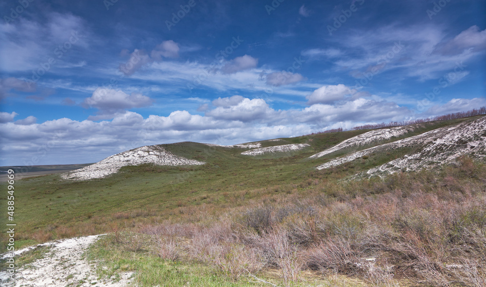 steppe landscape with spring grass chalk hills and bright blue sky steppe landscape with spring grass chalk hills and bright blue sky