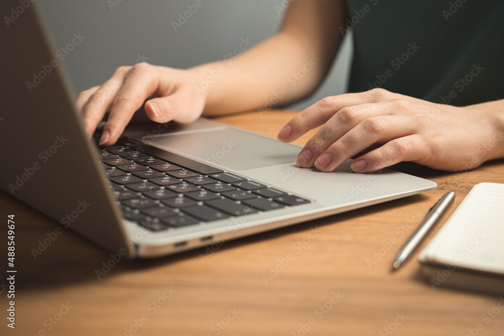 Laptop on wooden desk and young woman hand on keyboard. Freelance workplace, work from home concept background photo Laptop on wooden desk and young woman hand on keyboard. Freelance workplace, work from home concept background photo