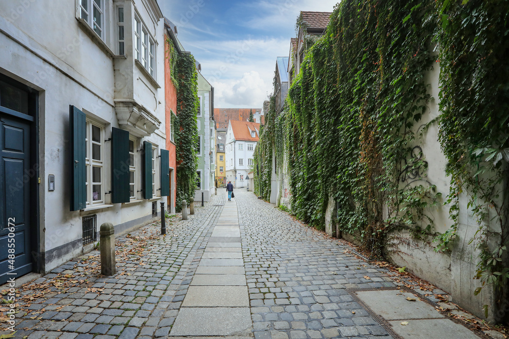 Bummel durch die romantische Altstadt von Augsburg mit Blick auf alte Häuser und eine von Efeu bewachsene, alte Mauer in der Schwabenstadt in Bayern, Deutschland.