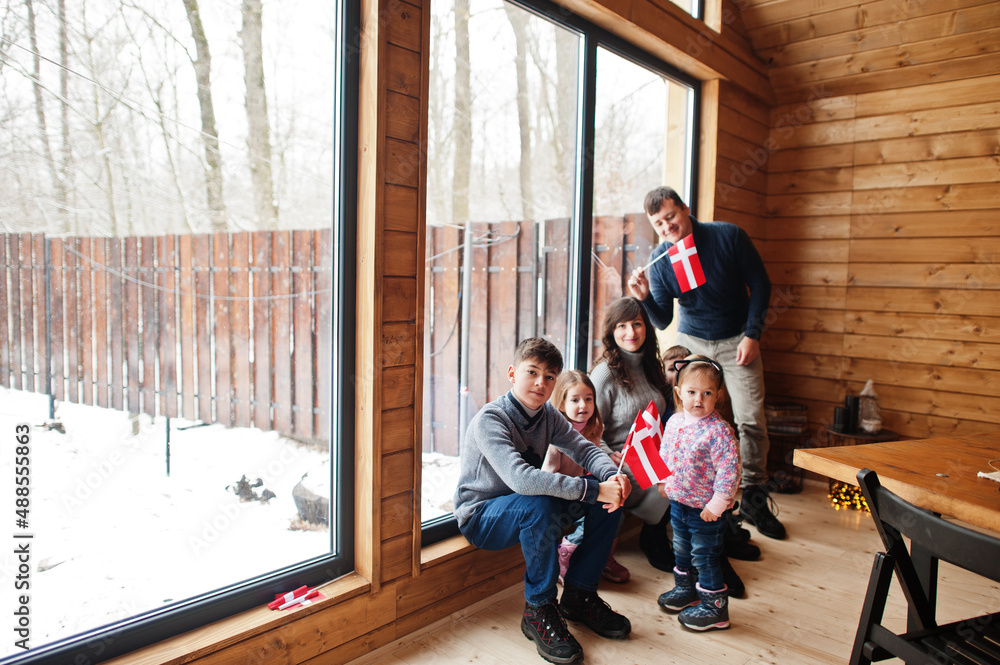 Family with Denmark flags inside wooden house. Travel to Scandinavian countries. Happiest danish people's . Family with Denmark flags inside wooden house. Travel to Scandinavian countries. Happiest danish people's .