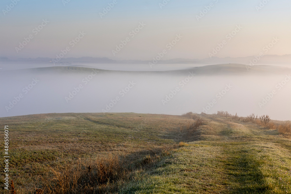 Tuscany landscape at sunrise with fog