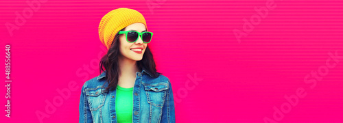 Summer portrait of happy smiling young woman wearing a colorful clothes, hat on pink background