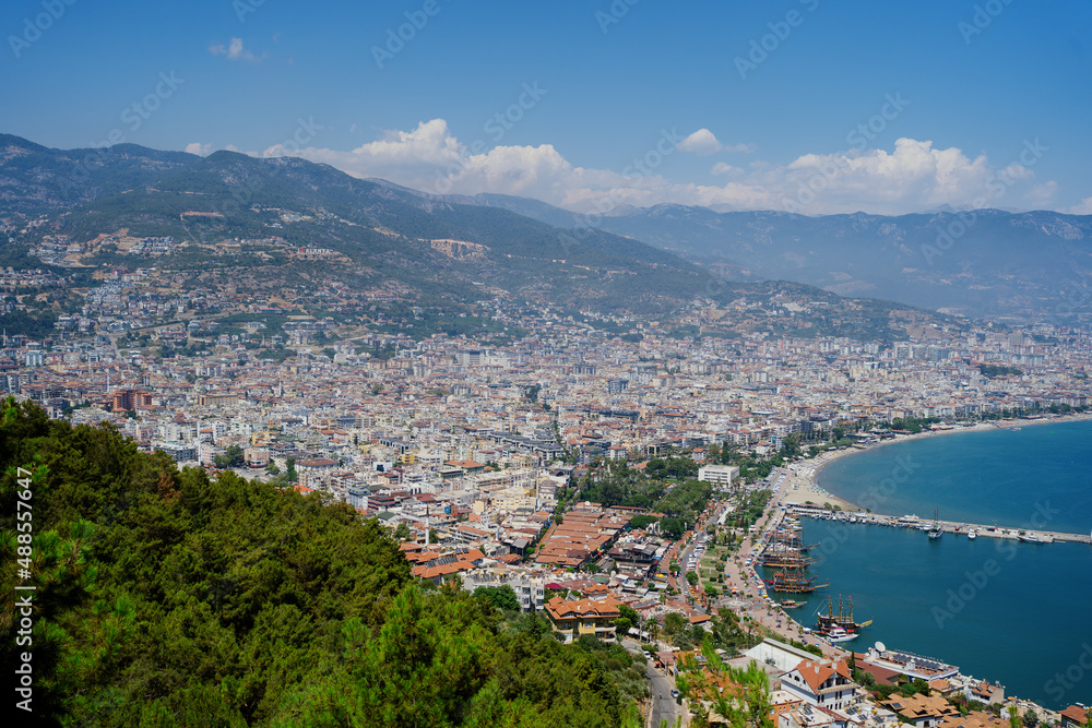 Alanya, Turkey - Day view on historical harbor of Alanya, the seashore and mountains with many houses on the coast