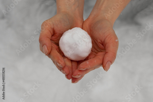 White ball of snow in hands