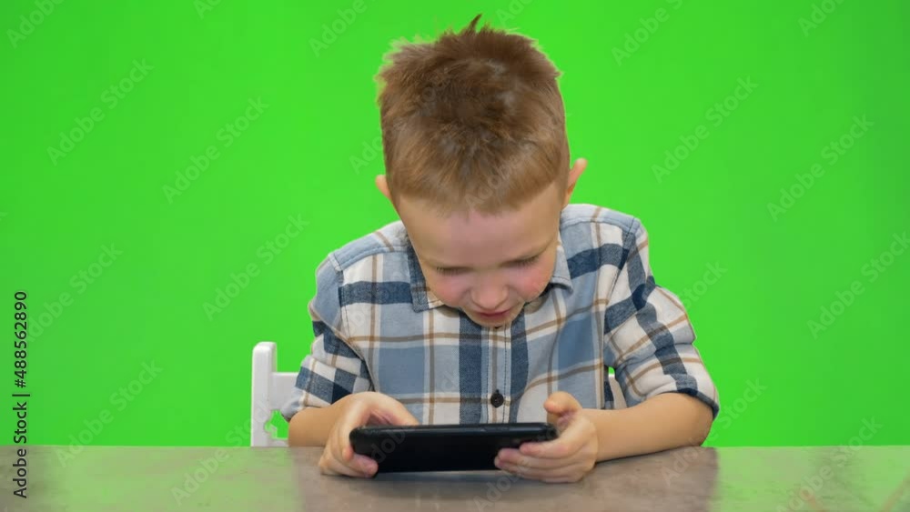 5 year old boy playing on smartphone, chroma key 5 year old boy playing on smartphone, chroma key