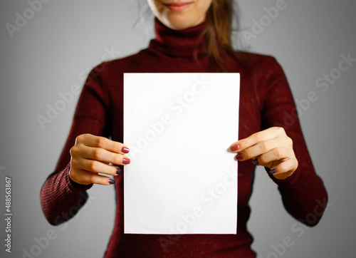 Woman showing blank white flyer paper. Leaflet presentation. Pamphlet hold hands. Girl show clear offset paper. Sheet template