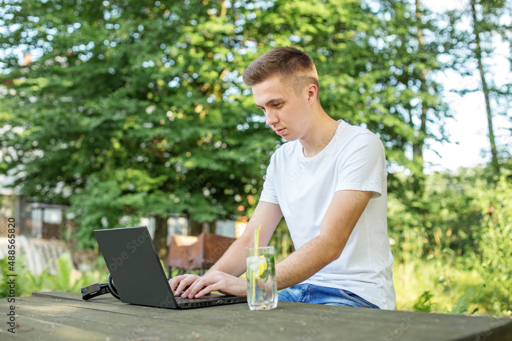 Person inspired by nature. Use Internet, laptop and headphones for remote work and learning. Delicious refreshing cocktail with mint and lemon Person inspired by nature. Use Internet, laptop and headphones for remote work and learning. Delicious refreshing cocktail with mint and lemon