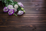 The beautiful purple flowers on a dark wooden background. Greeting card for holidays with copy space, top view