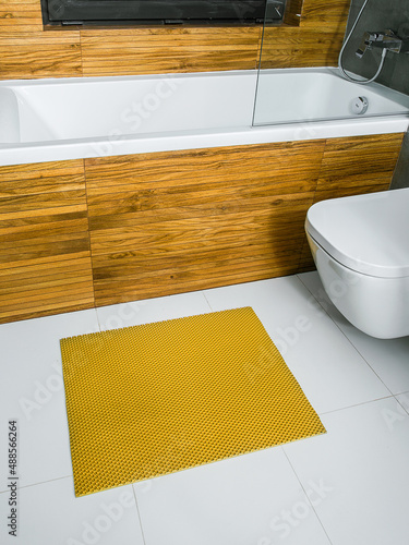 A rubber mat on the floor next to the bathtub in the bathroom. Interior design, modern bath