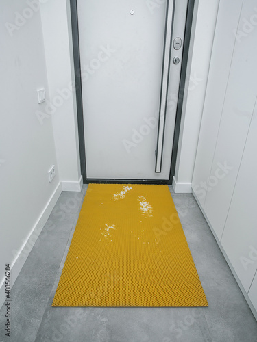 rubber door mat, front door, home with traces of dirt and snow