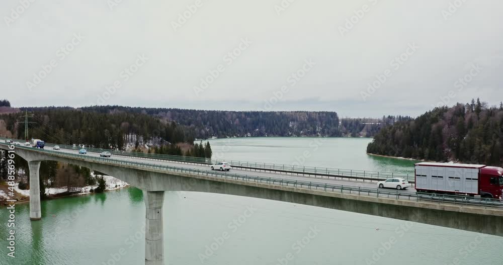 Quadcopter video of a bridge across a river to hills covered in snowy forest. Quadcopter video of a bridge across a river to hills covered in snowy forest.