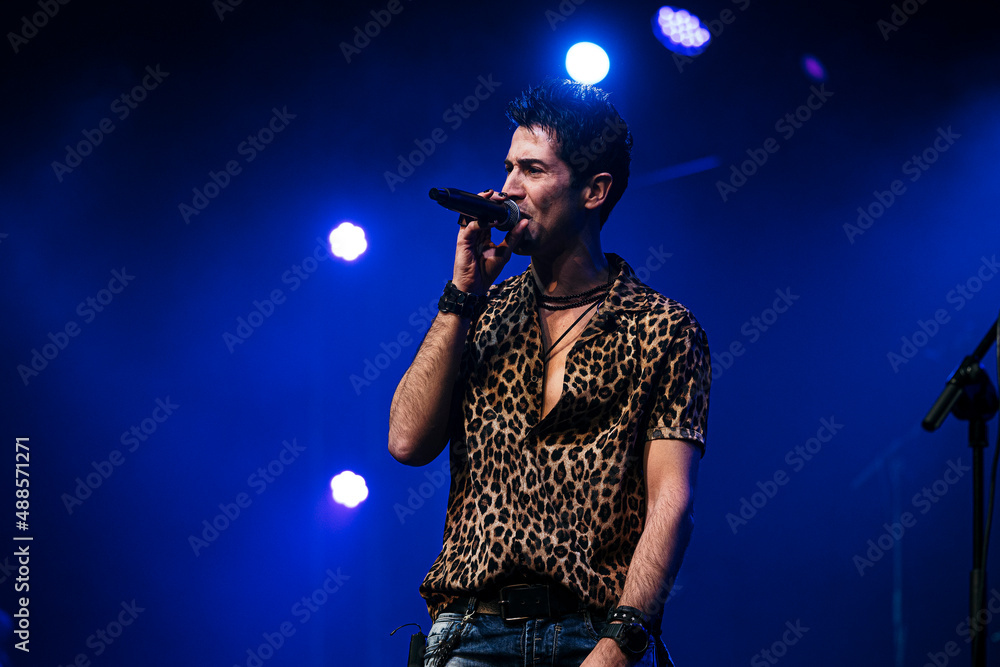Singing artist performing before the audience at a live concert. Singing artist performing before the audience at a live concert.